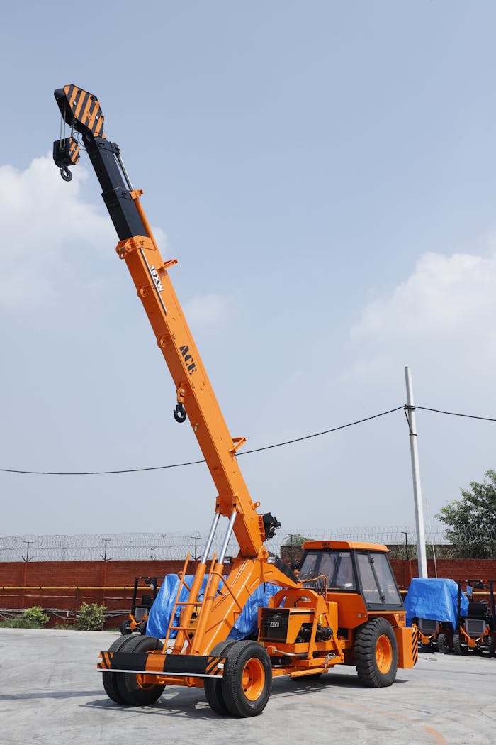 portfolio-01 Orange ACE mobile crane in use at an outdoor construction site in Faridabad, India.